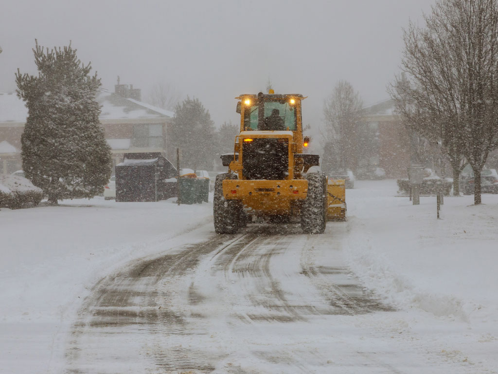 Truck removing snow and ice at the road